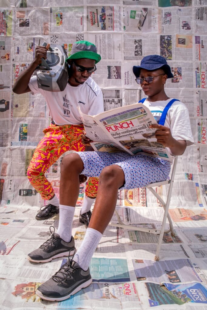 Two stylish men in Nigeria enjoying a sunny day with vintage style and flair.